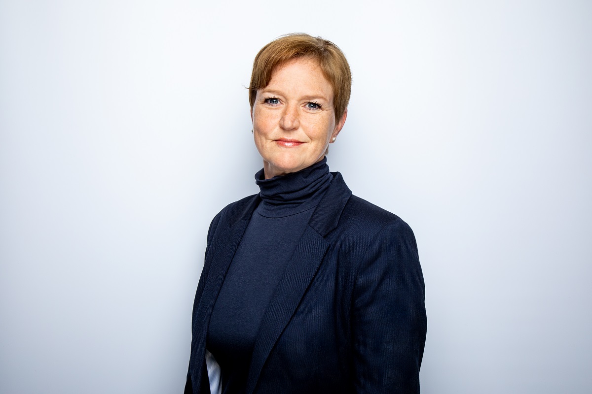 Dame med kort hår og mørk blå bluse